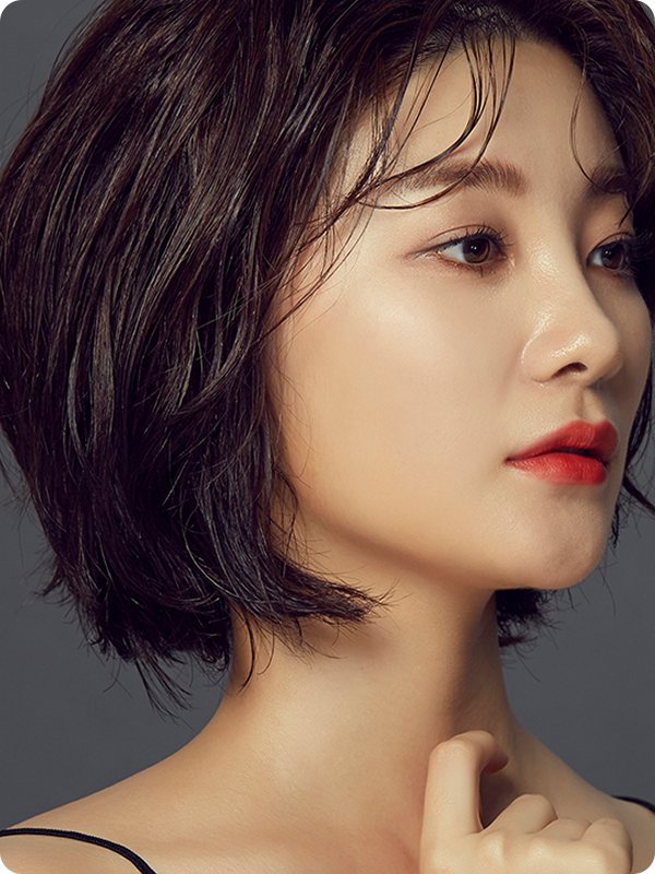 귀뒤돌려깎기 — 짙은 회색 바탕, 옆을 보는 단발 웨이브 모델의 턱선